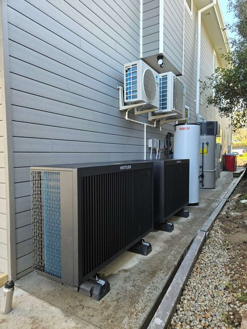 Two heat pumps for hydronic heating down the side of a house